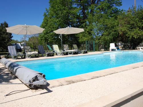 une piscine avec parasols et chaises et une piscine dans l'établissement Maison avec piscine chauffée privée, proche Lascaux et Dordogne, idéale famille et détente - FR-1-616-123, à Auriac-du-Périgord