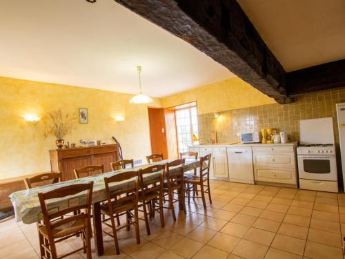une cuisine avec une table et des chaises dans une pièce dans l'établissement Maison isolée avec Terrasse, BBQ, et Jardin - Animaux acceptés - FR-1-616-154, à Villac