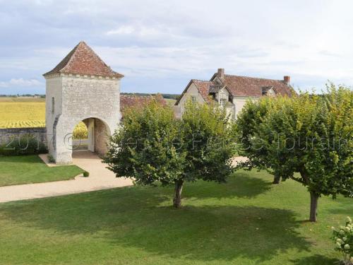 an old building with a gate and two trees at Maison de charme avec jardin clos près des vignobles - FR-1-381-262 in Parçay-sur-Vienne