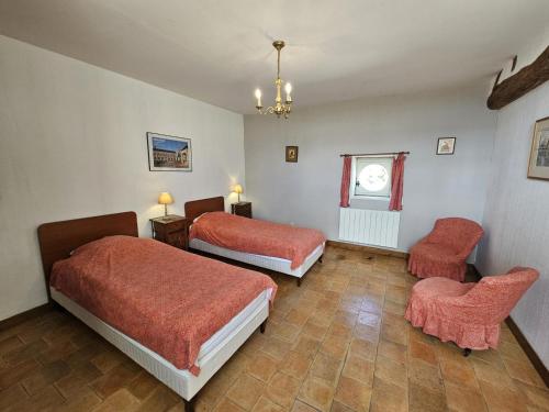 a hotel room with two beds and a chair at Maison de charme avec jardin clos près des vignobles - FR-1-381-262 in Parçay-sur-Vienne