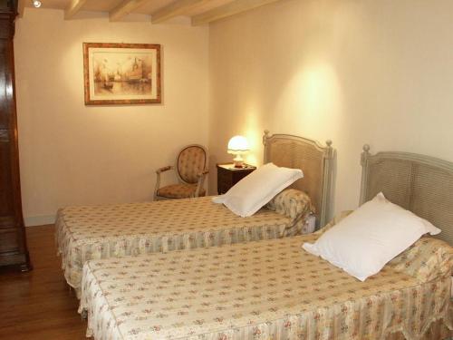 a hotel room with two beds and a table and chair at Gîte rural rénové 3 niveaux, jardin privatif, équipements loisirs, draps inclus, cheminée, WiFi - FR-1-381-475 in Bléré