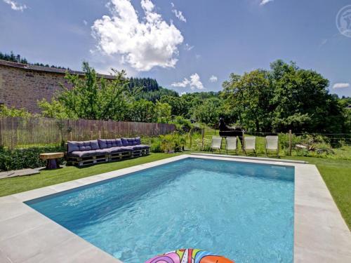 a swimming pool in the backyard of a house at Gîtes confortables avec piscine, accueil animaux, cheminée, jardin - FR-1-496-140 in Belmont-de-la-Loire