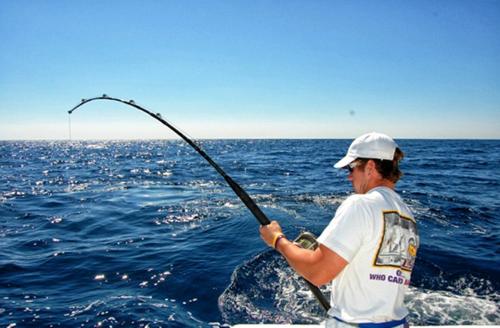 a man fishing in the ocean on a boat at Visit Sunny Beach Marina Apartments in Ravda
