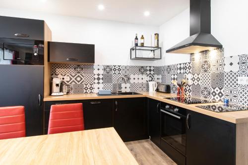a kitchen with black and white tiles on the wall at Gîte Jean Scafer, Piscine chauffée, Wifi, Salle de jeux, Animaux de la ferme in Beynat