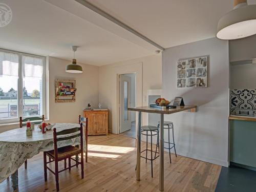 une cuisine et une salle à manger avec une table et des chaises dans l'établissement Charmant appartement contemporain avec patio cosy et toutes commodités à Chazelles-sur-Lyon - FR-1-496-298, à Chazelles-sur-Lyon