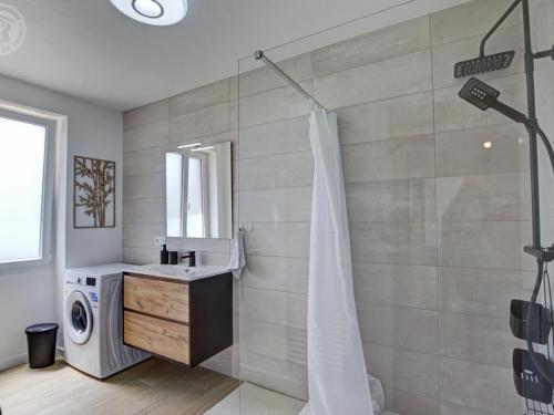 a bathroom with a shower and a washing machine at Gîtes Champêtres Rénovés avec Terrasse, Jardin, et Activités pour Familles et Amis - FR-1-496-304 in Belmont-de-la-Loire