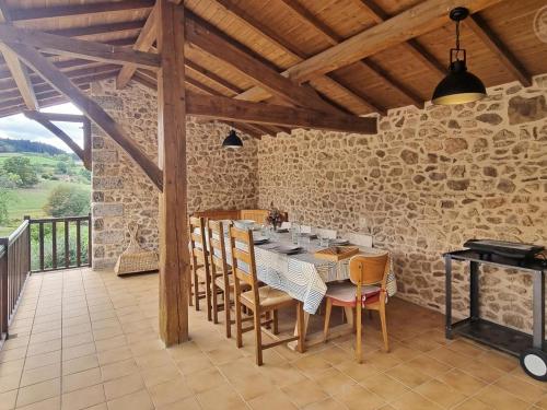 une salle à manger avec une table et des chaises dans l'établissement Gîtes Champêtres Rénovés avec Terrasse, Jardin, et Activités pour Familles et Amis - FR-1-496-304, à Belmont-de-la-Loire