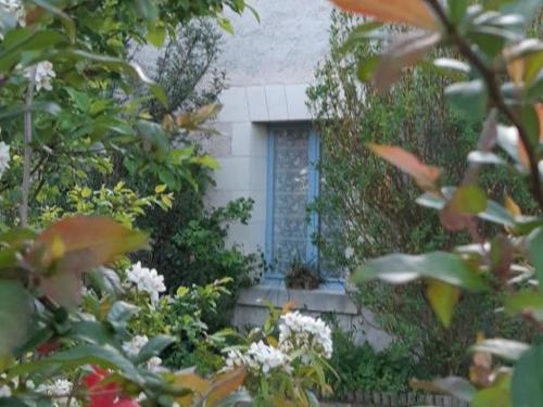 a house through the leaves of trees and flowers at Évasion à Luzillé : Havre de Paix avec Jardin Privatif, proche Chenonceau et Beauval - FR-1-381-303 in Luzillé