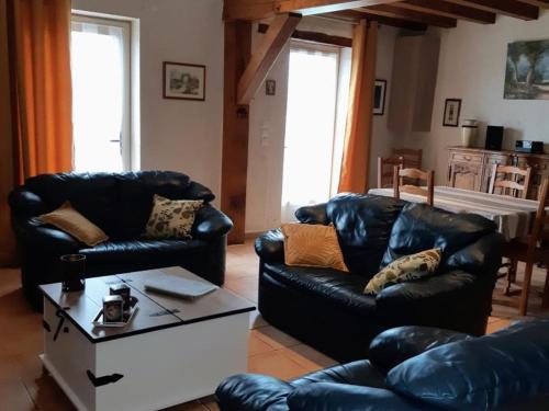 a living room with two leather couches and a coffee table at Évasion à Luzillé : Havre de Paix avec Jardin Privatif, proche Chenonceau et Beauval - FR-1-381-303 in Luzillé