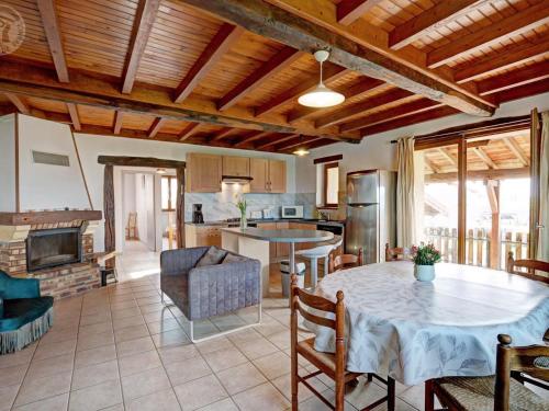 un salon avec une table et une cuisine dans l'établissement Gîte de charme avec cheminée, balcon et jardin à St-Médard-en-Forez - FR-1-496-279, à Saint-Médard-en-Forez