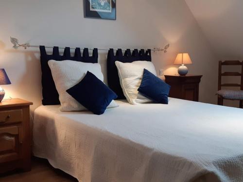 a bedroom with a large white bed with blue pillows at Évasion à Luzillé : Havre de Paix avec Jardin Privatif, proche Chenonceau et Beauval - FR-1-381-303 in Luzillé