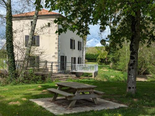 a picnic table in front of a white building at Gîte au Moulin: confort moderne avec terrasse et WIFI - FR-1-653-271 in Saint-Maurice-des-Lions