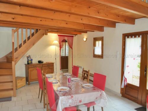 une salle à manger avec une table et des chaises rouges dans l'établissement Charmante maison proche de Tours, châteaux et vignobles, grand jardin, équipements modernes, WiFi. - FR-1-381-220, à Azay-sur-Cher