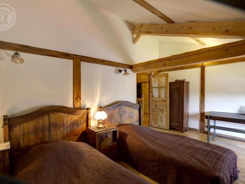 ein Schlafzimmer mit zwei Betten und einem Tisch mit Lampe in der Unterkunft Charmant Gîte pour 4 avec Jardin, Animaux Bienvenus - FR-1-496-191 in Saint-Georges-Haute-Ville