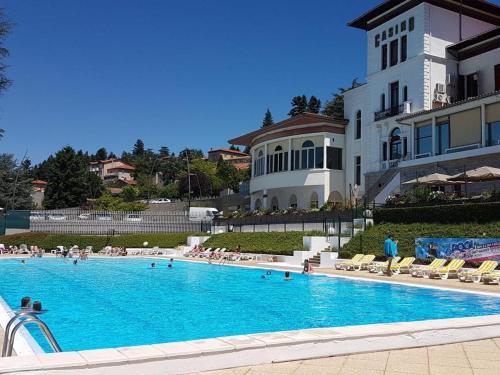 une grande piscine devant un immeuble dans l'établissement Gîte de charme avec terrasse, jardin et jeux - tout inclus, lits faits, linge fourni à Saint-Galmier - FR-1-496-300, à Saint-Galmier
