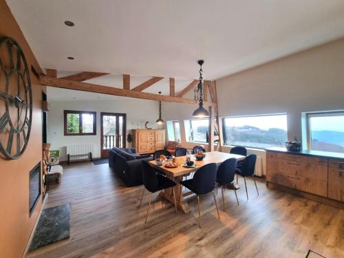 une salle à manger et un salon avec une table et des chaises dans l'établissement Gîte chaleureux au Bessat pour 6 à 8 pers., animaux admis, grand jardin - FR-1-496-350, à Le Bessat