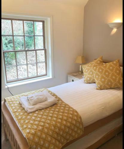 a bedroom with a large bed with a window at Rock View Cottage, 2 bedrooms near Alton Towers in Alton
