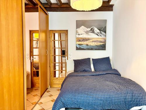 une chambre avec un lit avec une couette bleue dans l'établissement Appartement Central St Germain, à Paris