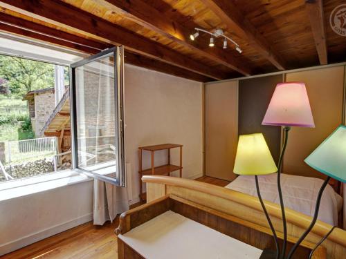 a living room with a bed and a window at Gîte Avec Piscine, Chevaux Acceptés, Confort Moderne - FR-1-496-126 in Belmont-de-la-Loire