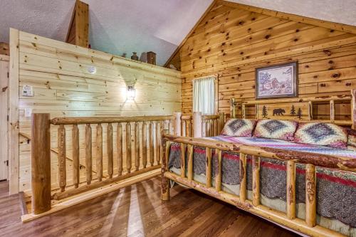 a log cabin bedroom with a bed and a couch at Forever Yours, 2 Hot tubs, FREE Attraction tickets, WIFI, Near The Parkway in Pigeon Forge!!! in Pigeon Forge