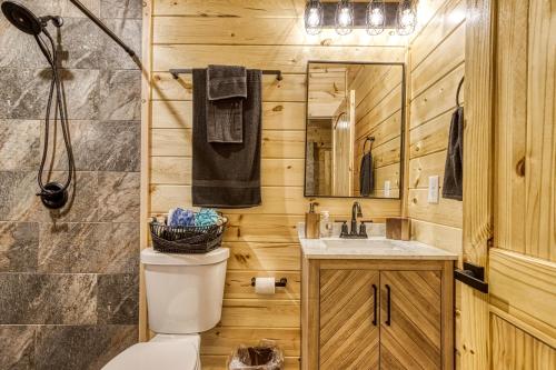 a bathroom with a toilet and a sink at Forever Yours, 2 Hot tubs, FREE Attraction tickets, WIFI, Near The Parkway in Pigeon Forge!!! in Pigeon Forge