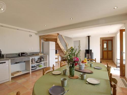 a kitchen and dining room with a table and chairs at Gîte spacieux avec terrasse en forêt, 12 lits, proche randonnées - FR-1-496-314 in Verrières-en-Forez
