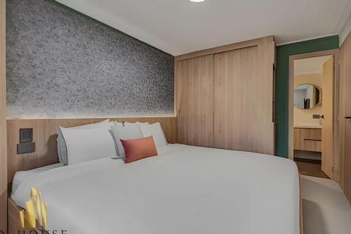 a bedroom with a large white bed and a bathroom at Paola 201 - Charm and perfect location in Laureles in Guayaquil