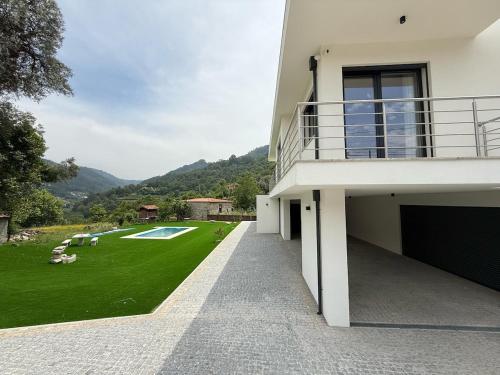 a view of a house with a green yard at Refúgio da Avó - Gerês in Terras de Bouro