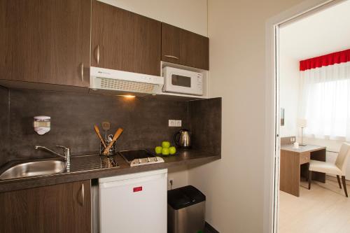 a kitchen with a sink and a microwave at Residhome Reims Centre in Reims