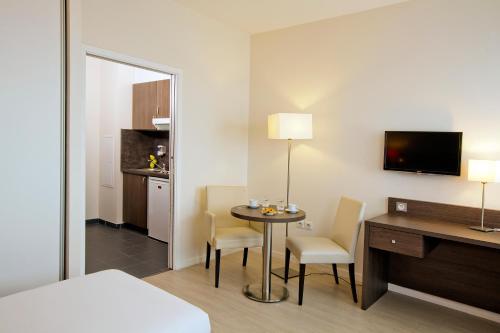 a hotel room with a bed and a table and chairs at Residhome Reims Centre in Reims