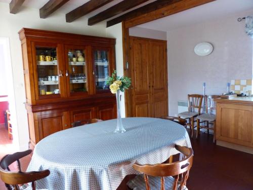 une table de salle à manger avec un vase de fleurs dessus dans l'établissement Maison rénovée à Franchesse avec grand jardin et animaux admis - FR-1-489-221, à Franchesse
