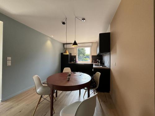 une cuisine et une salle à manger avec une table et des chaises dans l'établissement Gîte Contemporain au Cœur du Village avec Jardin et Climatisation - FR-1-489-551, à Ébreuil