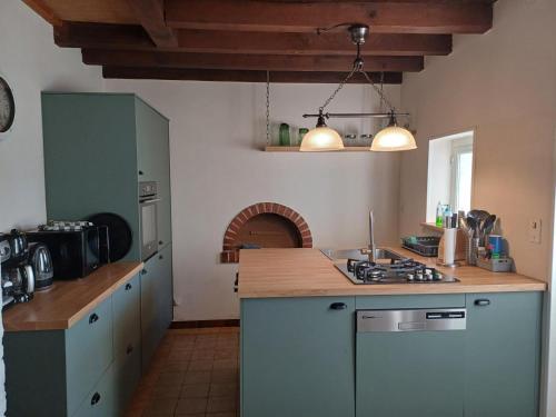 une cuisine avec des armoires bleues et un comptoir dans l'établissement Gîte charme en pleine nature pour 6 pers - FR-1-489-565, à Saint-Félix