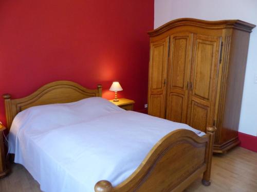 une chambre avec un lit blanc et une armoire en bois dans l'établissement Maison familiale au calme avec jardin clos, proche thermes - FR-1-489-563, à Néris-les-Bains