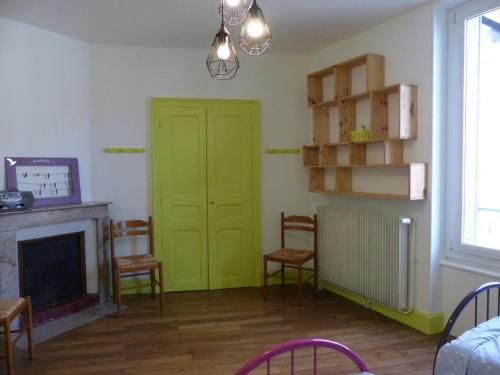 - un salon avec une porte et des chaises vertes dans l'établissement Maison familiale au calme avec jardin clos, proche thermes - FR-1-489-563, à Néris-les-Bains