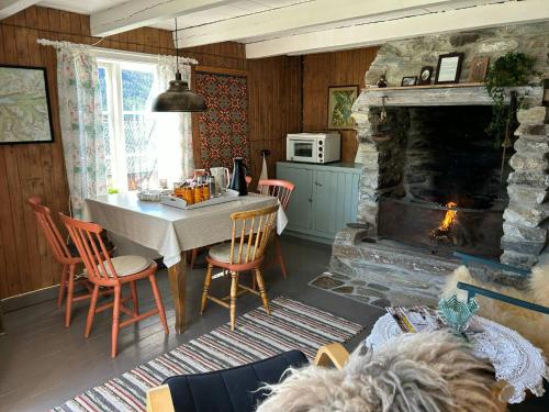 a living room with a table and a fireplace at Historic Farmhouse In Scenic Isfjorden in Isfjorden
