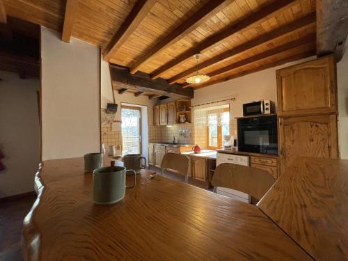 une cuisine et une salle à manger avec une table en bois dans l'établissement Maison Authentique avec Jardin et Cheminée, Animaux Acceptés, Parking, Internet - FR-1-489-184, à Laprugne