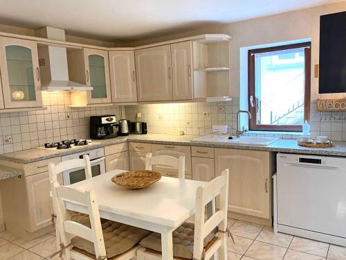 a kitchen with a table and chairs and a sink at Gîte cosy avec spa, grand jardin, proche de la rivière Sioule - idéal pour famille et relaxation - FR-1-489-342 in Saint-Bonnet-de-Rochefort