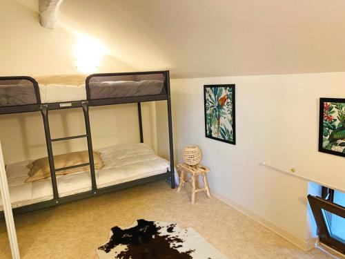 a room with two bunk beds and a chair at Gîte cosy avec spa, grand jardin, proche de la rivière Sioule - idéal pour famille et relaxation - FR-1-489-342 in Saint-Bonnet-de-Rochefort
