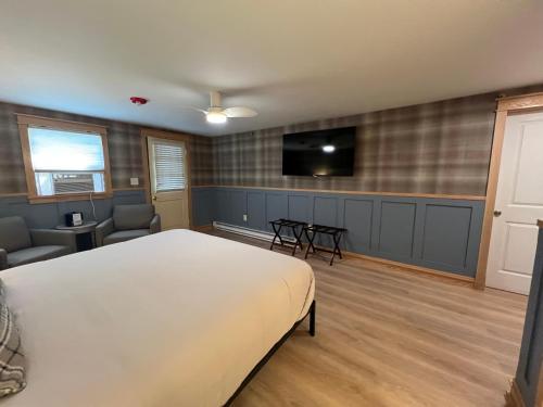 a bedroom with a bed and a flat screen tv at Stonehurst Manor Breakfast & Dinner Included in North Conway