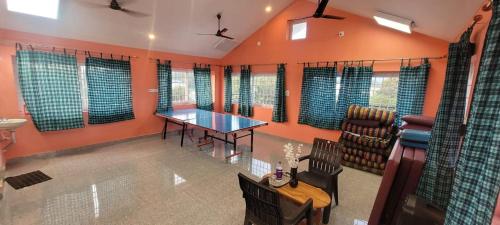 a living room with a table and chairs and windows at PK Residency in Yelagiri