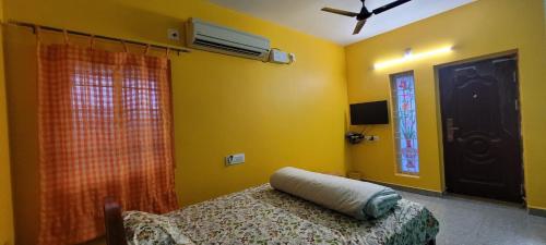 a bedroom with a bed and a window and a fan at PK Residency in Yelagiri