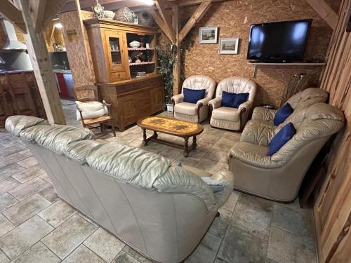 a living room with two couches and a tv at Gîte familial avec piscine chauffée, sauna et activités sur domaine de 15 hectares - FR-1-489-357 in Vernusse