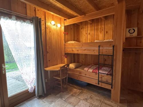 a bedroom in a log cabin with a bunk bed at Gîte familial avec piscine chauffée, sauna et activités sur domaine de 15 hectares - FR-1-489-357 in Vernusse
