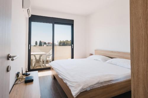 a bedroom with a bed and a view of a balcony at Apartment L'ideal in Ulcinj