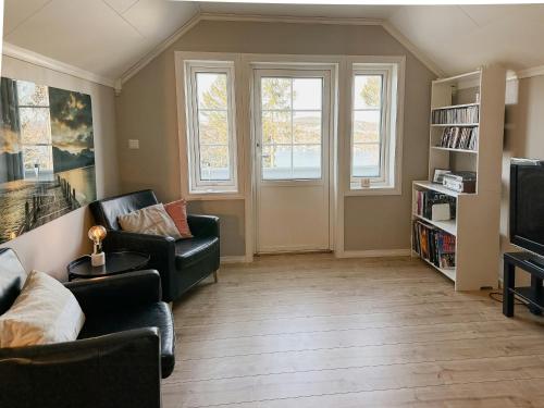 a living room with a couch and a tv at Cozy Cabin With Archipelago View, Kragerø in Stabbestad