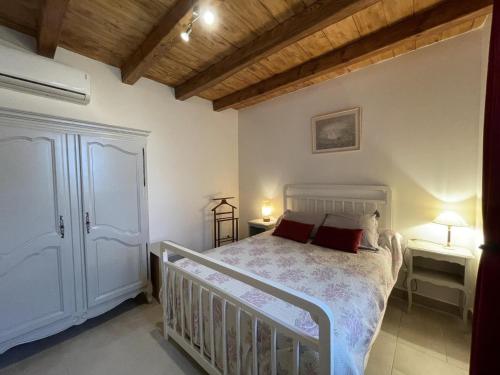 una camera da letto con un letto bianco con due tavoli e due lampade di Maison rénovée en campagne avec jardin privé et tout confort, près de Vichy - FR-1-489-381 a Rongères