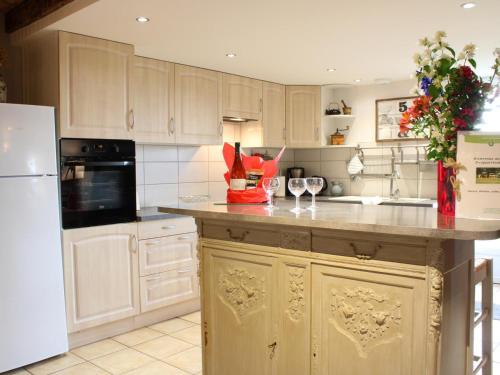 une cuisine avec des placards blancs et un comptoir avec des verres à vin dans l'établissement Gîte familial rénové à la campagne avec jardin, 4 chambres, proche loisirs et attractions - FR-1-489-61, à Cindré