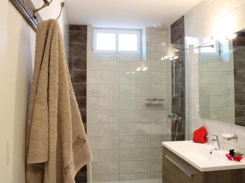 a bathroom with a sink and a shower with a towel at Gîte familial rénové à la campagne avec jardin, 4 chambres, proche loisirs et attractions - FR-1-489-61 in Cindré
