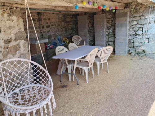 une table et des chaises bleues dans une pièce extérieure dans l'établissement Aventure en plein air: gîte familial avec activités, proche La Loge des gardes et Paléopolis - FR-1-489-454, à La Chabanne